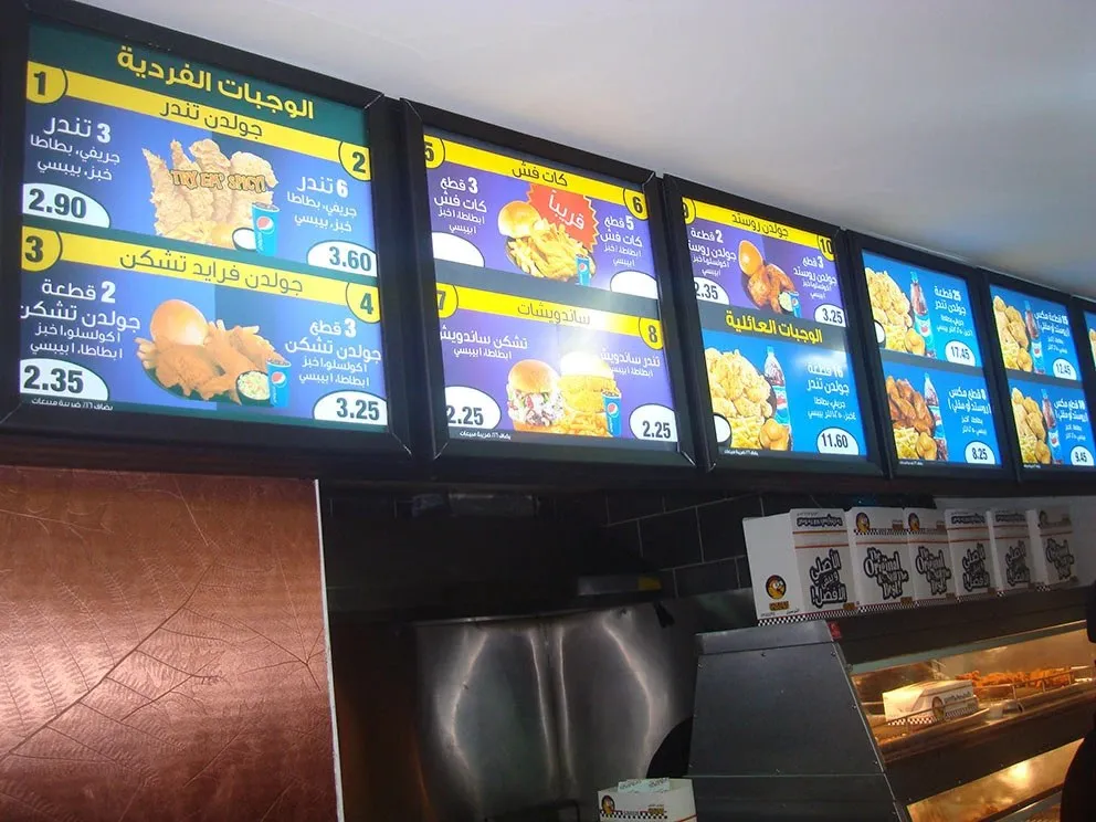 Illuminated menu boards above a restaurant counter