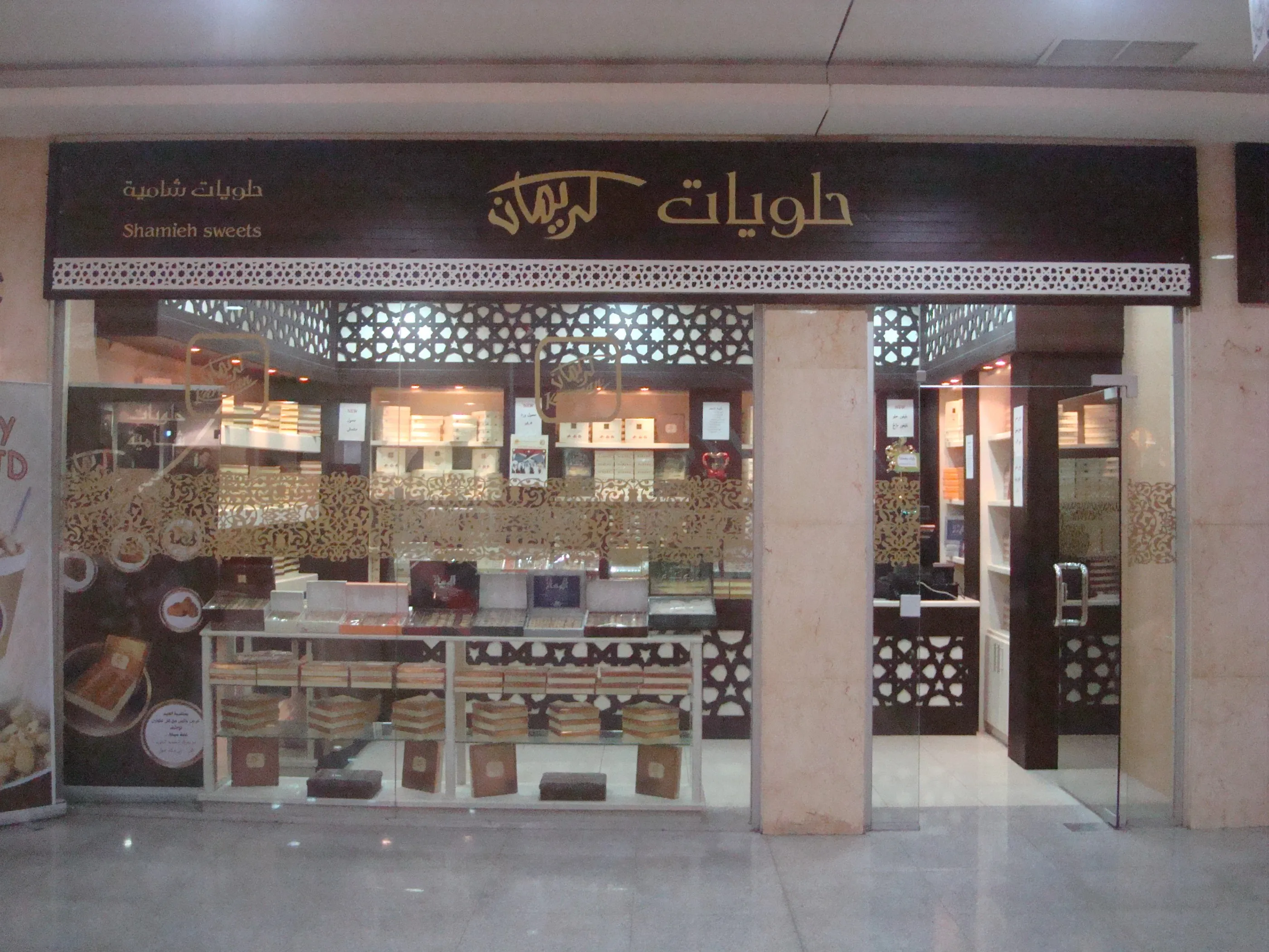 Sweet shop front with a carved wooden sign and patterned glass